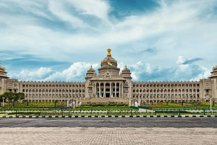 The grand Vidhana Soudha building in Bangalore under a cloudy sky